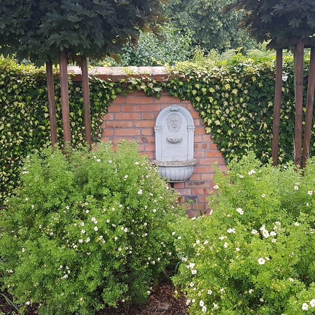 Zakładanie ogrodów Bydgoszcz - fontanna ścienna w ogródku.